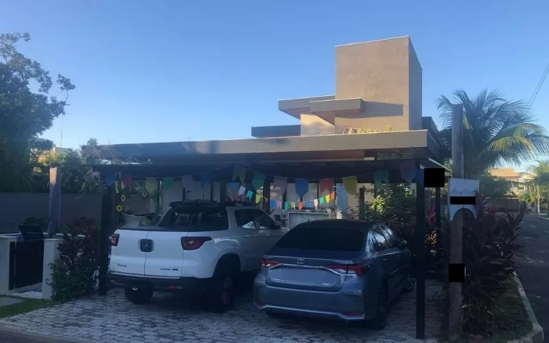 Garagem com dois carros e bandeirinhas decorativas.