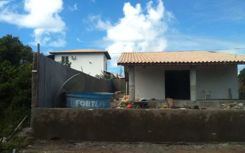 Casa em construção com materiais e contentor