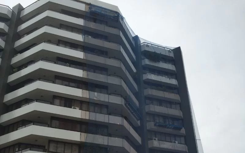 Edifício residencial com varandas e redes de segurança.