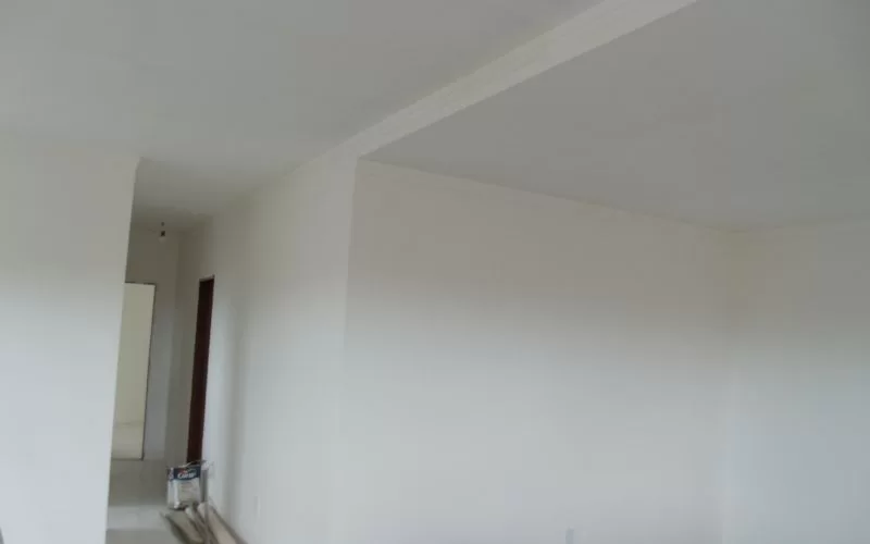 Sala pintada de branco com chão de madeira.