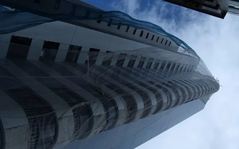 Edifício alto coberto por rede de segurança