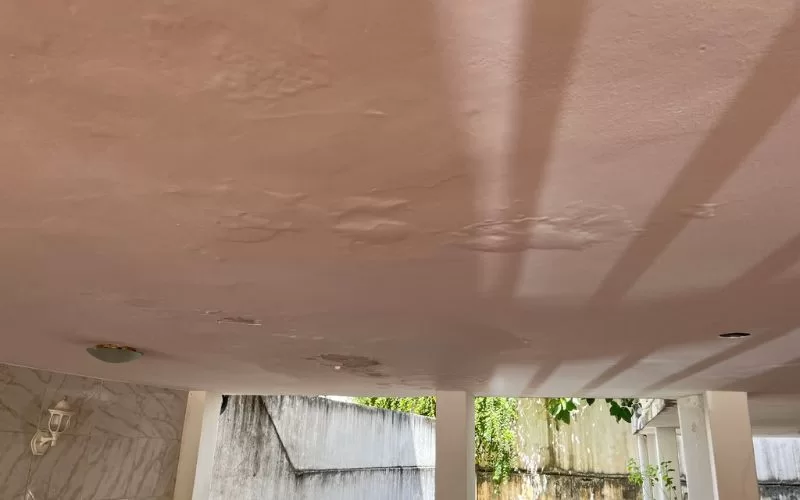 Teto com infiltrações e sombras visíveis.