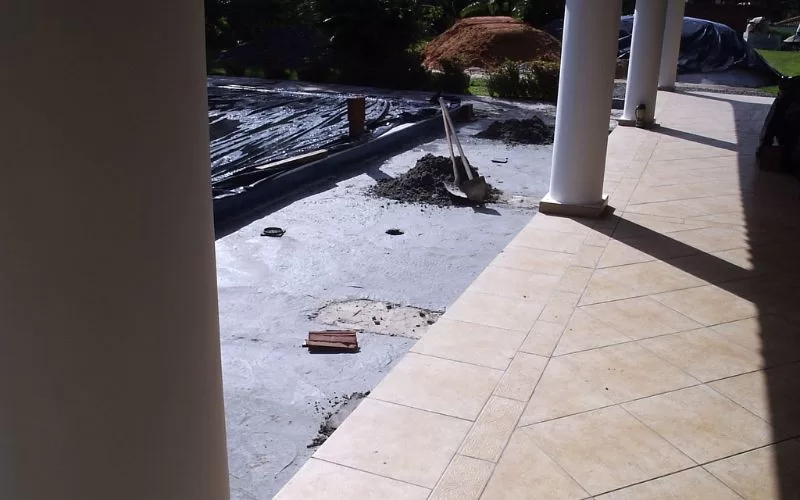 Construção de piscina em andamento com piso de mosaico.