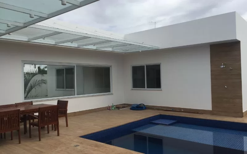 Casa moderna com piscina e varanda coberta.