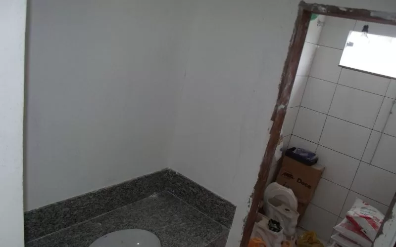 Casa de banho em remodelação com materiais no chão.