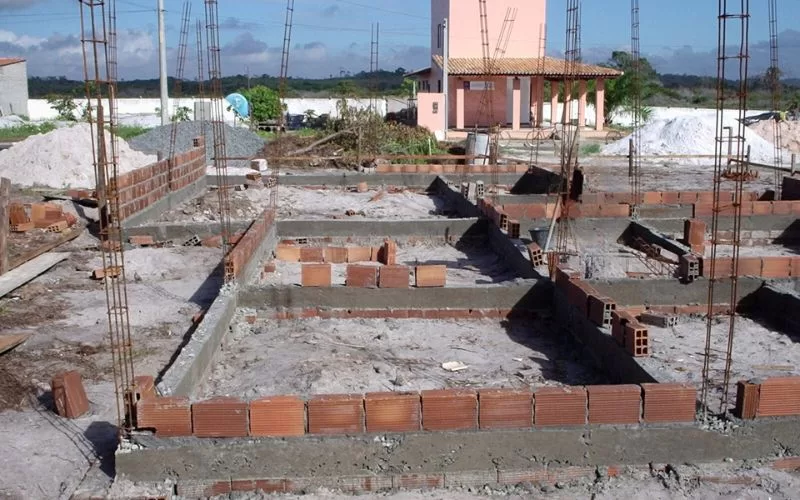 Fundação de casa em construção, tijolos à vista.