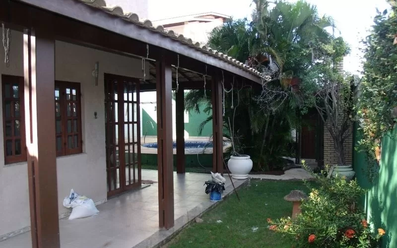 Varanda com jardim e piscina ao fundo.