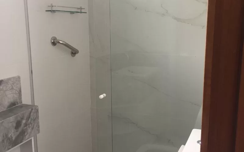Casa de banho moderna com chuveiro de vidro.