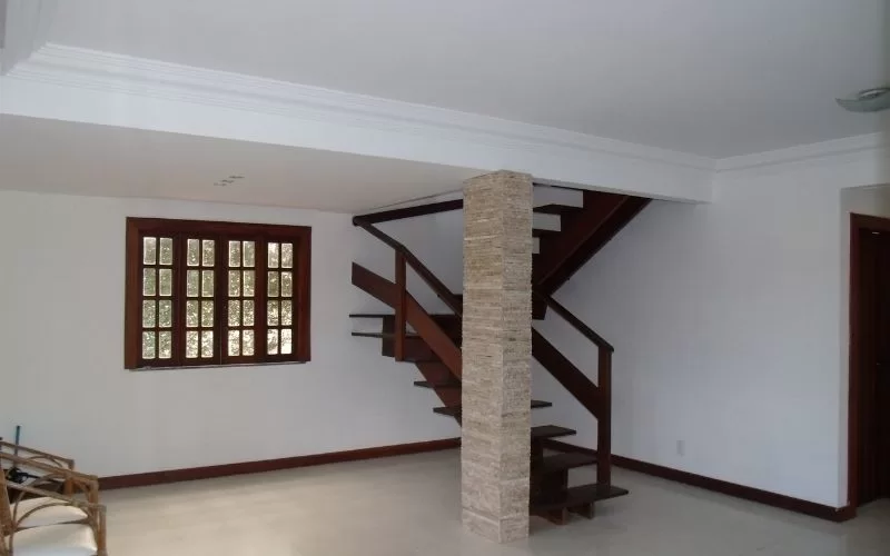 Sala moderna com escada de madeira.