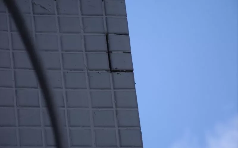 Prédio com azulejos quebrados e céu azul