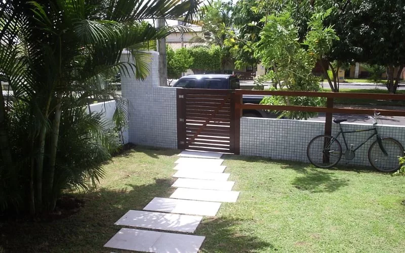Jardim com bicicleta ao lado do portão.