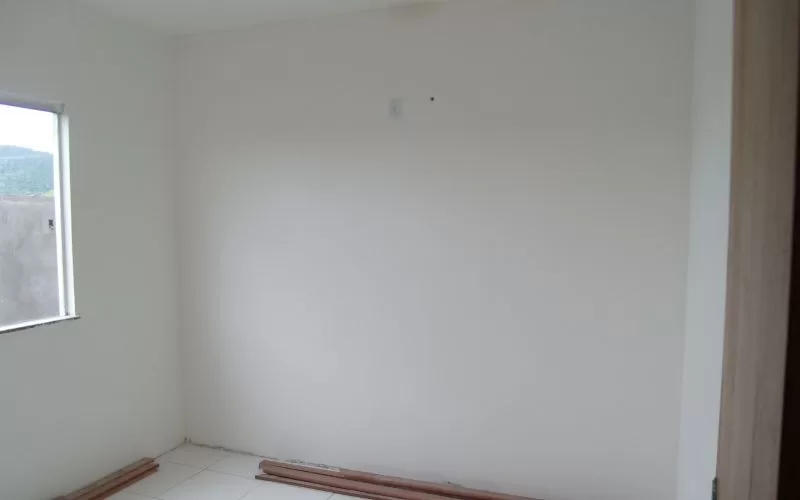 Quarto vazio com paredes brancas e janela