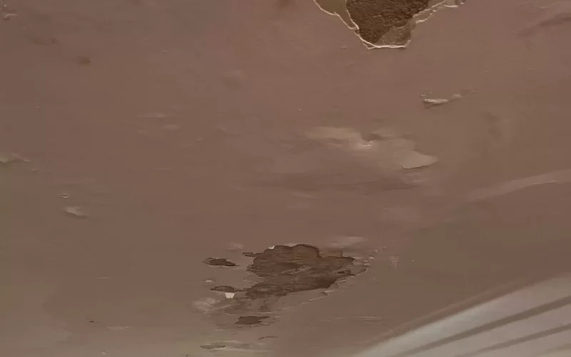 Teto danificado com infiltrações visíveis.