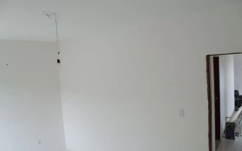 Quarto vazio com lâmpada pendurada no teto.