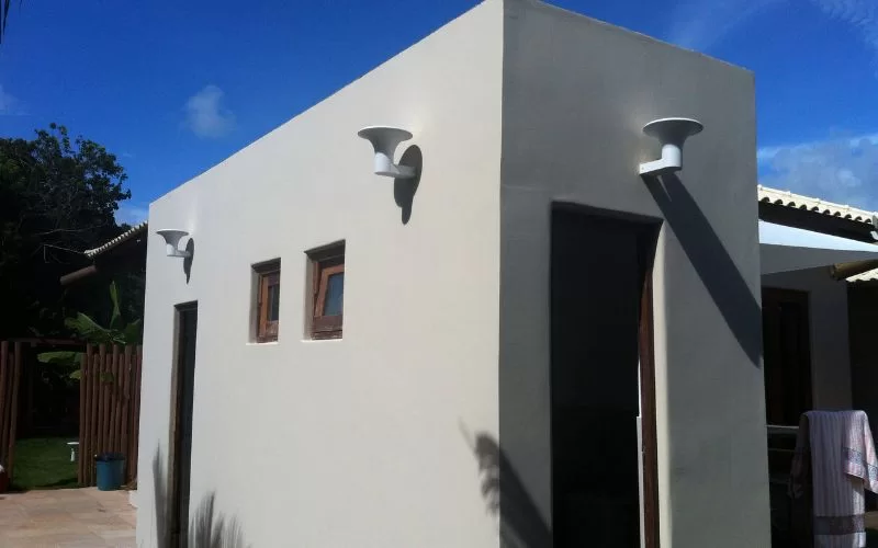 Parede externa com três apliques brancos.