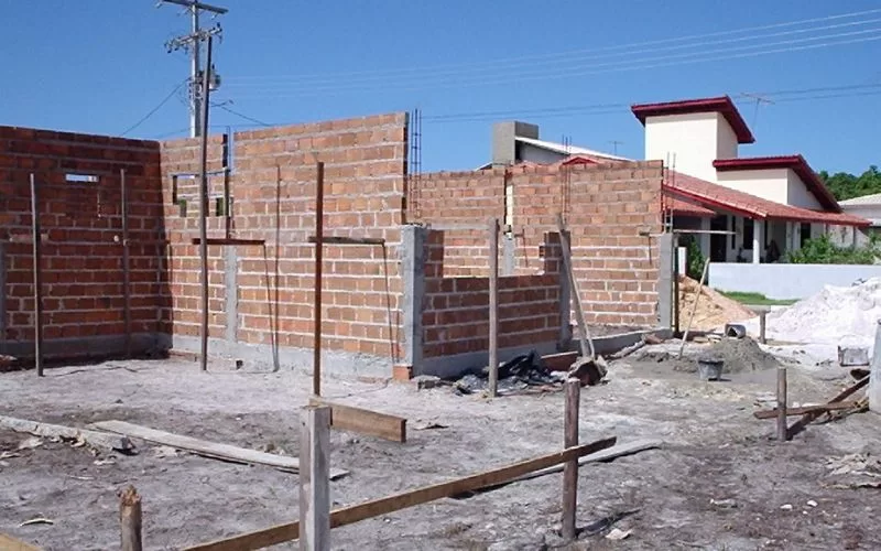 Construção de casa em alvenaria com tijolos expostos.