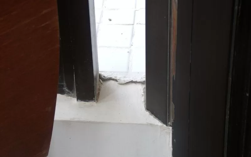 Porta mal encaixada na moldura de madeira