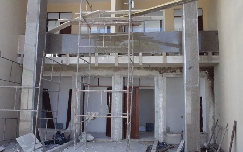 Construção de edifício com andaimes e materiais expostos.