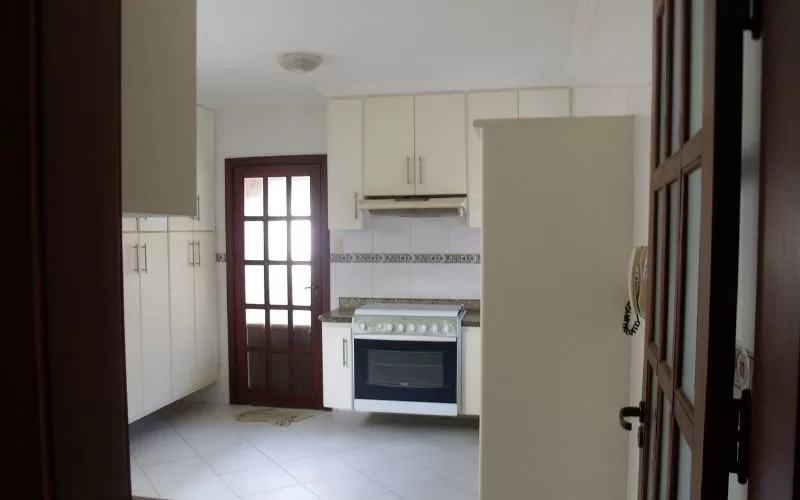 Cozinha moderna com armários brancos e fogão.