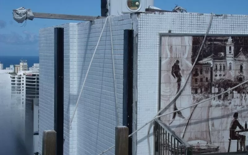 Mosaico histórico em fachada de edifício urbano.