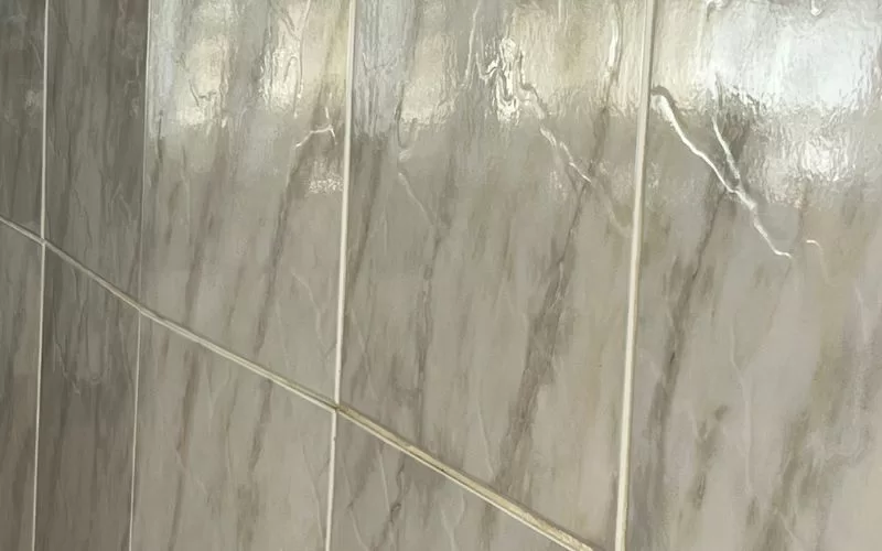 Azulejos de parede com textura marmorizada clara.