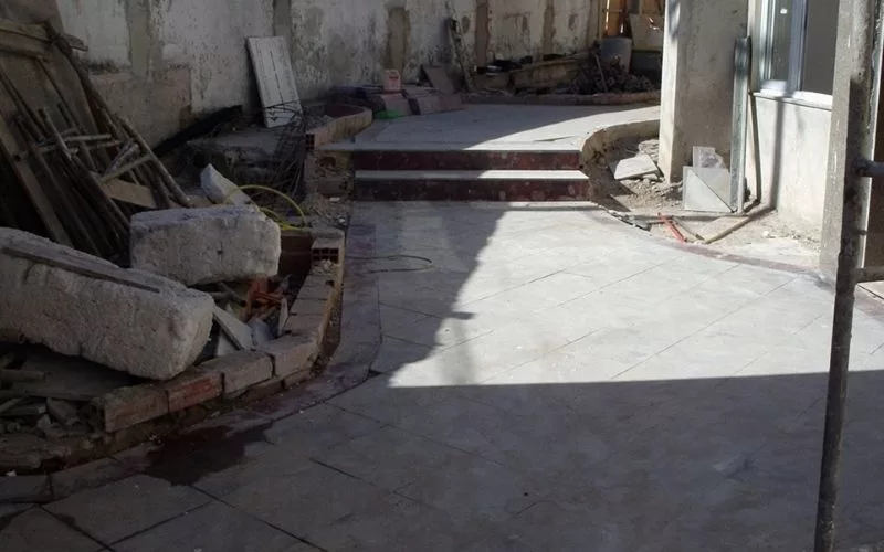 Área de construção com degraus e materiais empilhados.