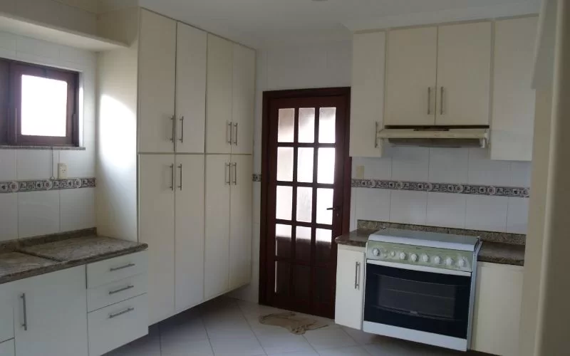 Cozinha moderna com armários brancos e fogão.