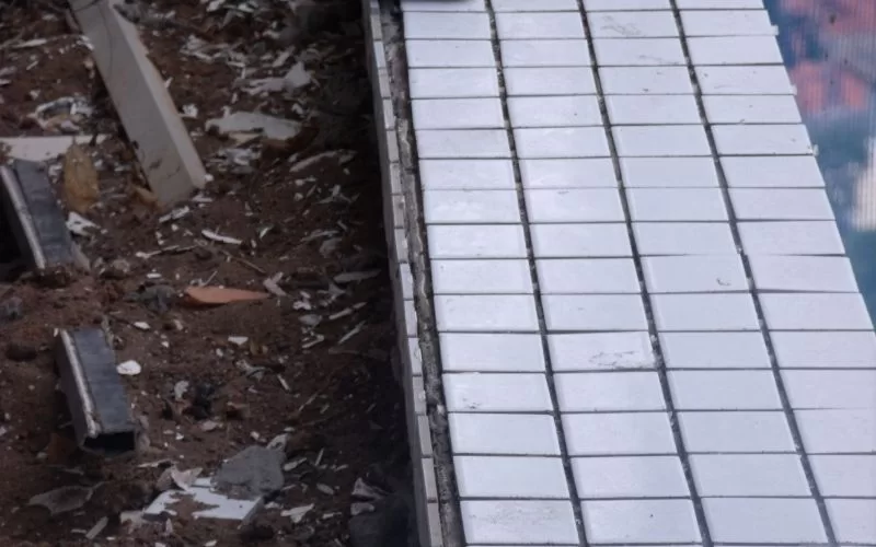 Piscina em construção com azulejos brancos.