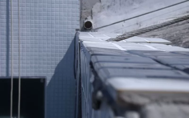 Canto de piscina vazia com azulejos azuis.