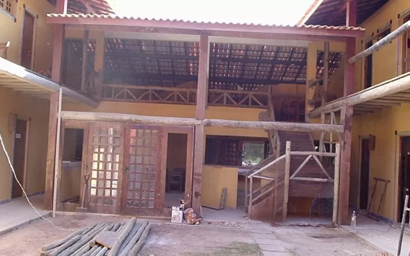 Edifício de madeira com escadas e varanda ampla.