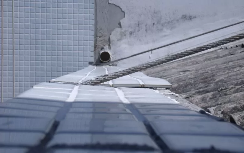 Reparação de telhado com azulejos danificados