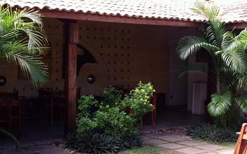 Pátio com mesas e plantas tropicais