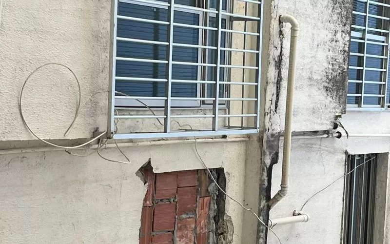 Janela com grades e parede danificada