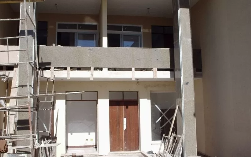 Construção de casa com andaimes exteriores visíveis.