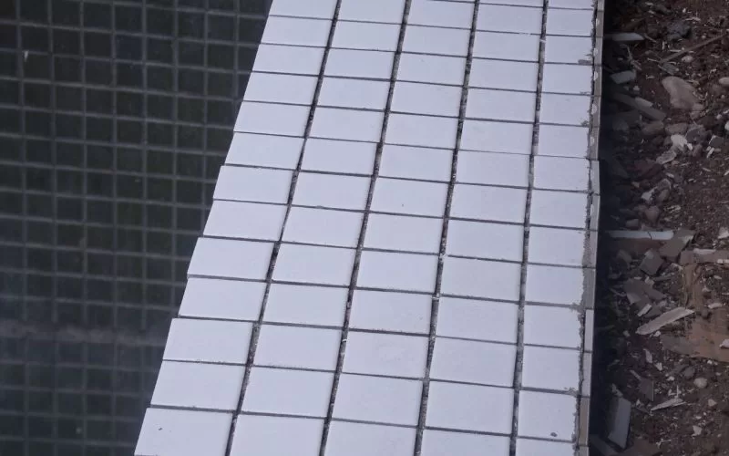 Mosaico de azulejos brancos quebrados em construção