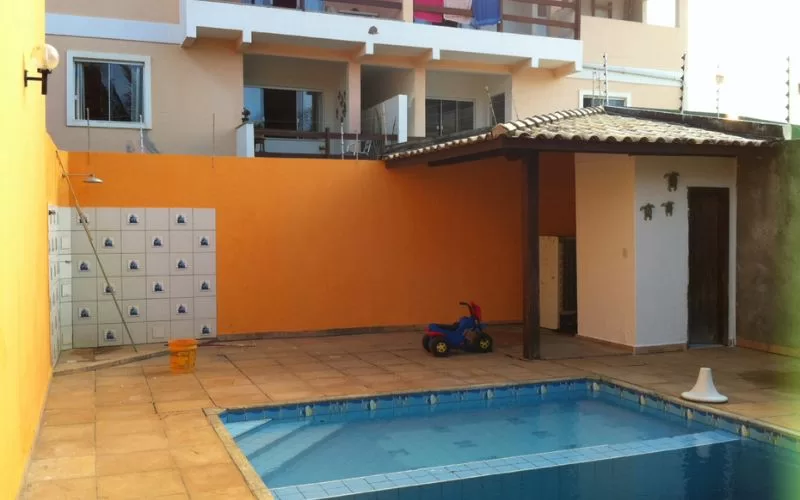 Piscina com área de lazer e brinquedo infantil.