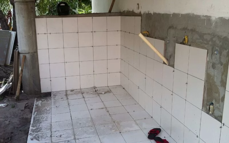 Reforma de cozinha com azulejos brancos.