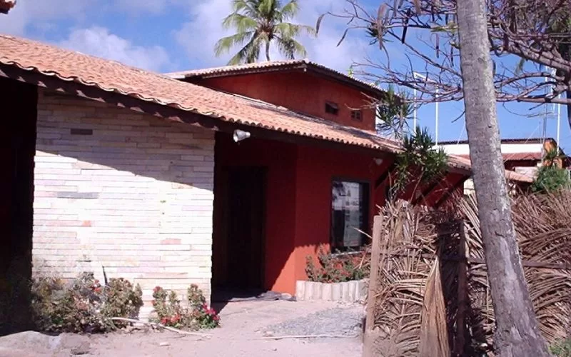 Casa com telhado de telha em ambiente tropical.