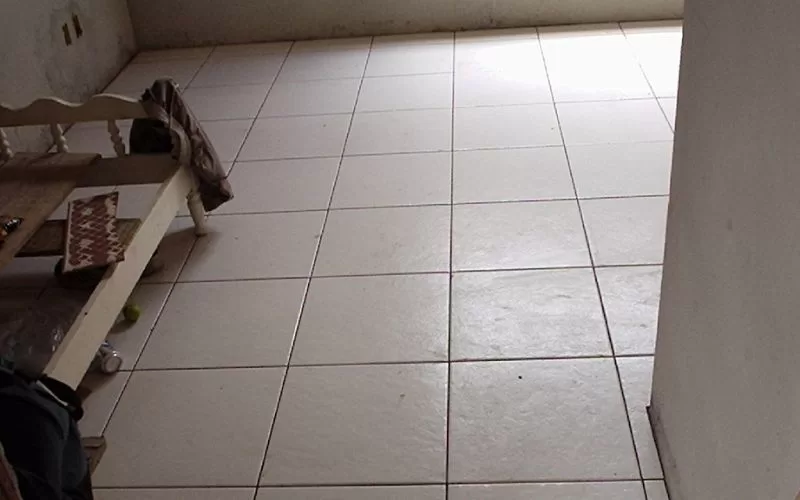 Quarto com piso de azulejos brancos.