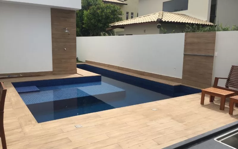 Piscina moderna com deck em madeira.