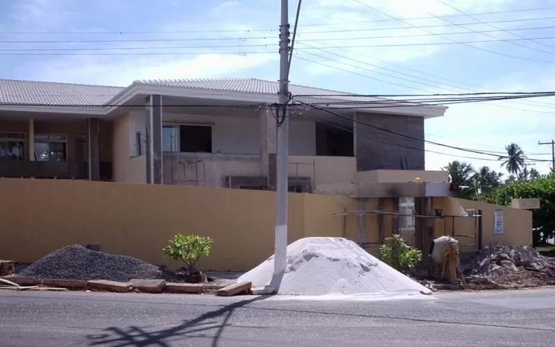 Construção de casa em andamento com materiais na frente.