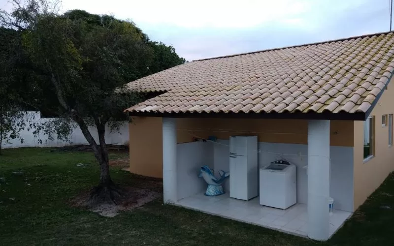 Varanda com máquina de lavar e frigorífico ao ar livre.