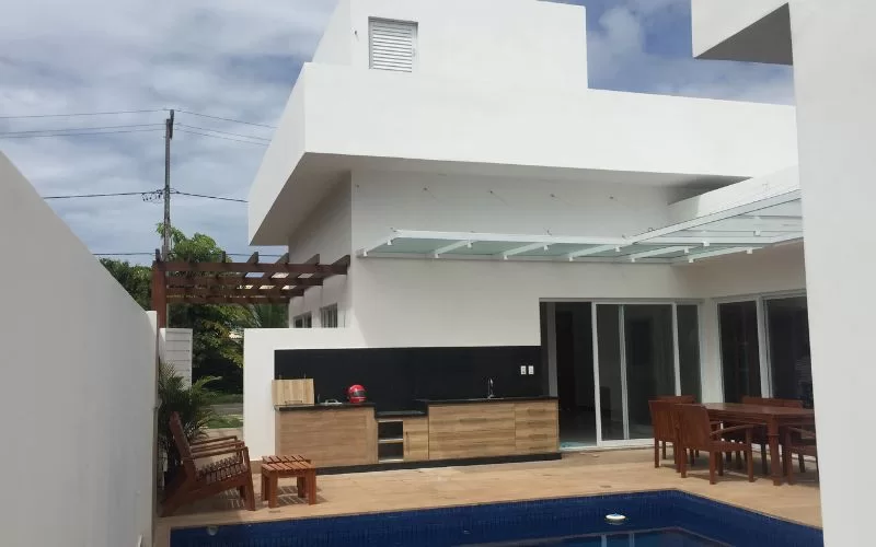 Casa moderna com piscina e área de lazer externa.