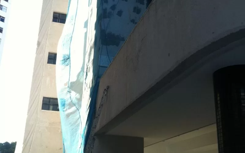 Prédio com rede de segurança azul na fachada