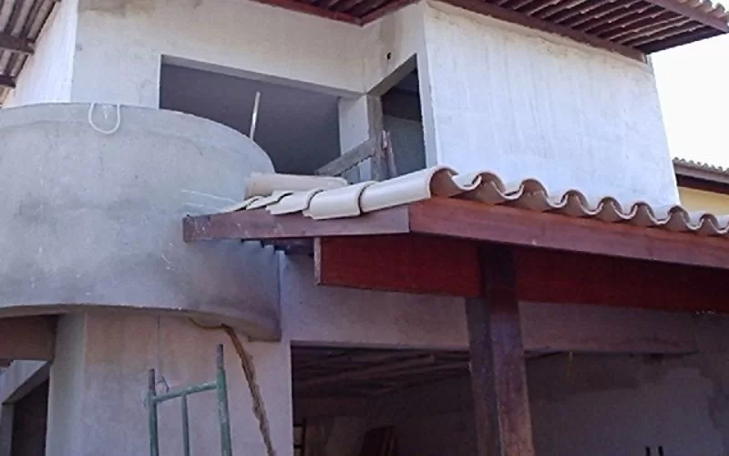 Construção de casa inacabada com telhado e varanda