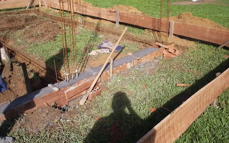Fundação de obra com armação de ferro e pá.