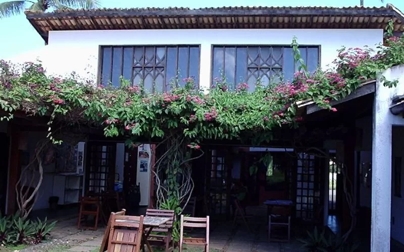 Casa com varanda coberta de flores e plantas.