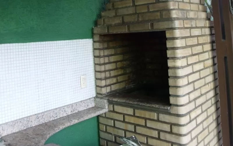 Churrasqueira de tijolos em área externa.