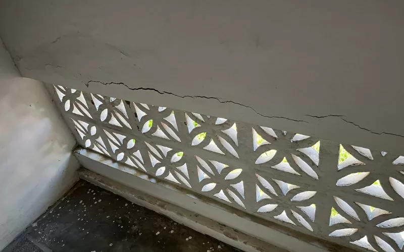 Parede rachada com detalhes decorativos.