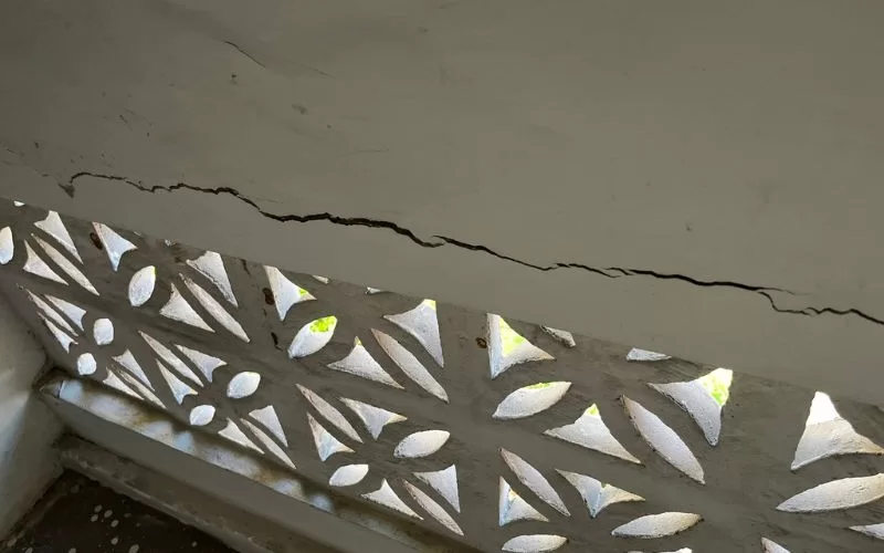 Fenda numa parede de varanda com padrão decorativo.